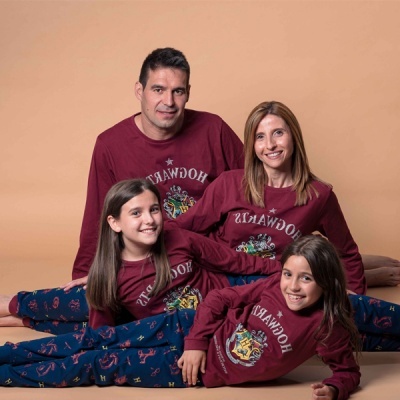 Família com pijamas Hogwarts em fundo bege