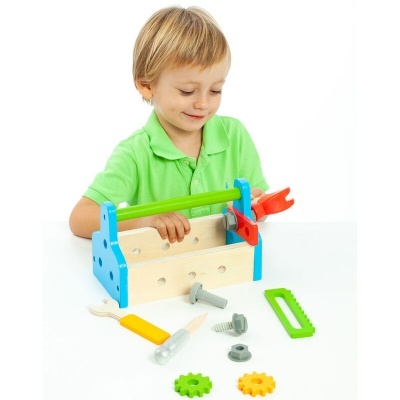 Criança a brincar com caixa de ferramentas de madeira colorida e ferramentas de plástico.