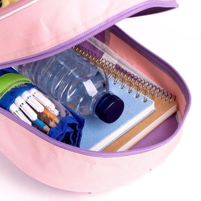 Bolsa rosa aberta com garrafa de água, estojo de lápis e dois cadernos espiralados dentro