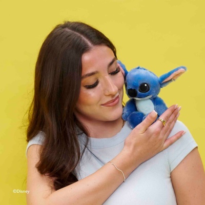 Mulher com peluche azul do Stitch da Disney