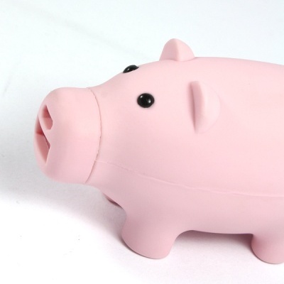 Brinquedo em forma de porco rosa claro com olhos pretos sobre superfície branca