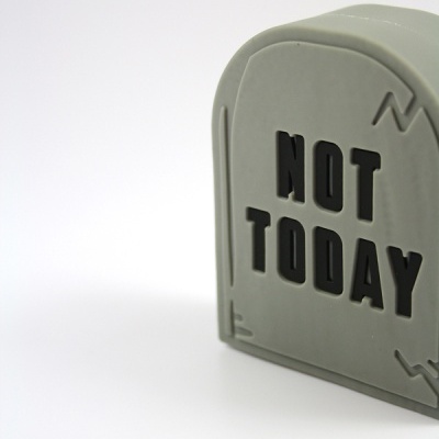 Objeto cinzento com texto preto NOT TODAY em relevo