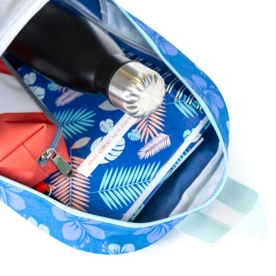 Mochila azul floral aberta com conteúdos visíveis