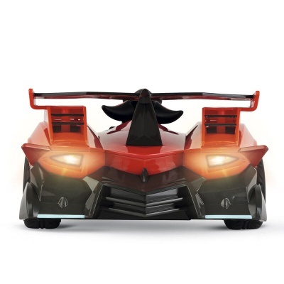 Carro desportivo em miniatura vermelho e preto com faróis ligados visto de frente