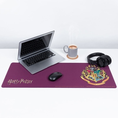 Tapete para rato roxo com brasão de Hogwarts e texto Harry Potter num ambiente de escritório com computador, rato, auscultadores e chávena.