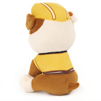 Pelúcia de cão com capacete e uniforme amarelo sentado de costas