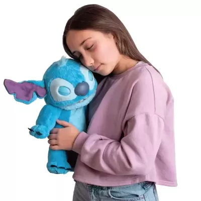 Menina abraçando peluche azul do Stitch.