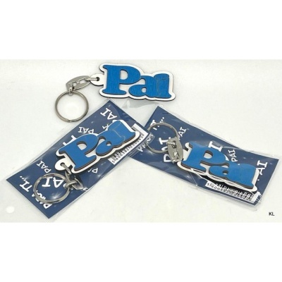 Porta-chaves com a palavra 'Pai' em azul e branco, três embalados em cartão azul e um solto.