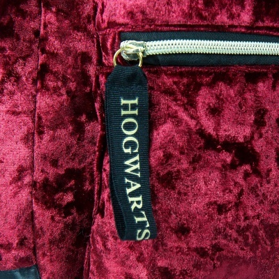 Mochila de veludo vermelho escuro com fecho e puxador preto com texto HOGWARTS