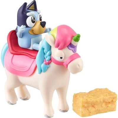 Figura de plástico de um cão azul a cavalo em cavalo branco com crina colorida e sela rosa, acompanhado de uma esponja amarela.