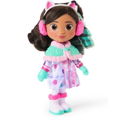 Boneca com casaco lilás, capa verde, luvas verdes, botas brancas e protetores de orelhas rosas.