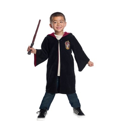 Criança com capa preta e vermelho segurando varinha mágica