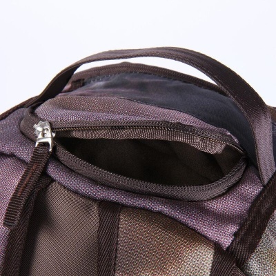 Mochila castanha com fecho metálico aberto no compartimento superior