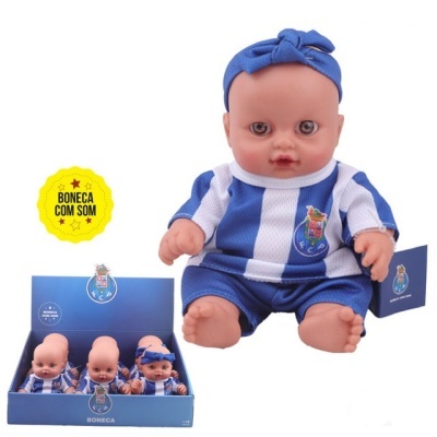 Boneca de bebé vestida com uniforme azul e branco do FC Porto, com faixa azul na cabeça, em caixa azul com o logo FCP
