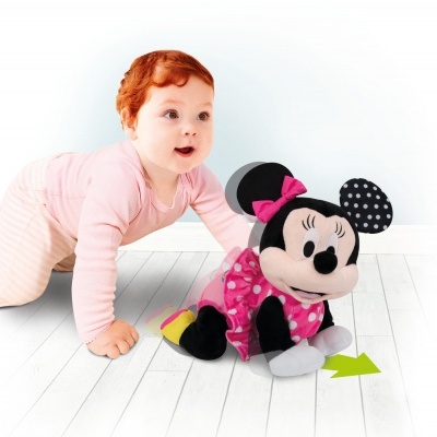 bebé com peluche Minnie Mouse em chão claro