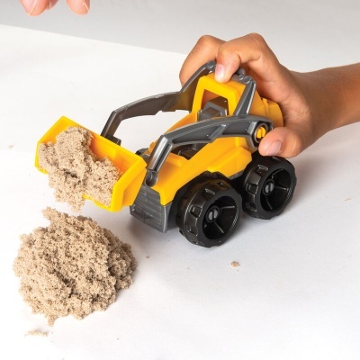 Miniatura de veículo de construção amarelo transportando areia