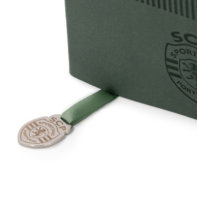 Caixa verde escura com etiqueta e pendente metálico com emblema SCP