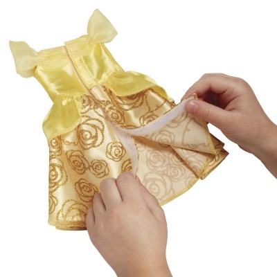 Vestido amarelo dourado para boneca com padrão de rosas, mãos a desdobrar o vestido