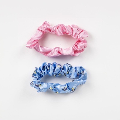 Dois elásticos de cabelo em tecido, um rosa e outro azul claro com padrão, sobre fundo branco.