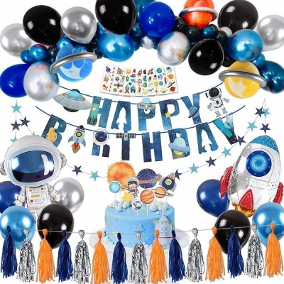 Decoração de aniversário temática espacial com balões, astronauta, foguete, faixa HAPPY BIRTHDAY e bolo azul com planetas.