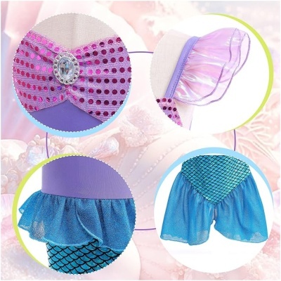 Detalhes de uma fantasia colorida com toppers rosa com lantejoulas, mangas transparentes e calções com padrão de escamas azuis