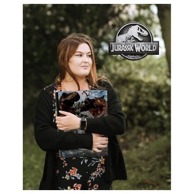 Mulher com pasta do Jurassic World segura caderno ao ar livre