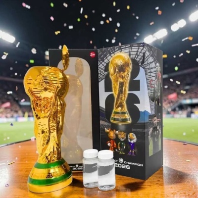 Estatueta dourada da Taça do Mundo de futebol com caixa e duas garrafas pequenas