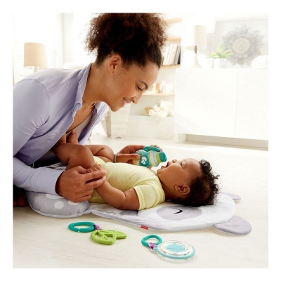 Bebé deitado em tapete de gato e mulher a segurá-lo e brincar com brinquedos