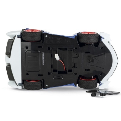 Carro de brinquedo branco visto de baixo com rodas vermelhas e compartimentos visíveis