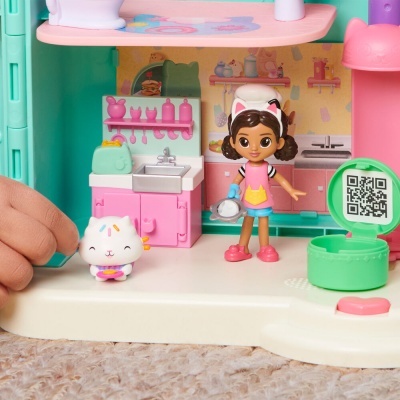Brinquedo de cozinha com figuras de menina e gato em ambiente colorido