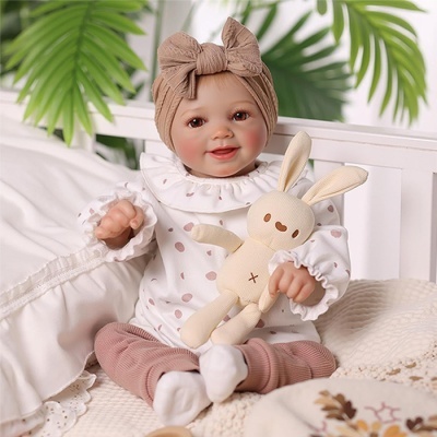 Boneca bebé sorridente com faixa cor-de-rosa e peluche coelho bege