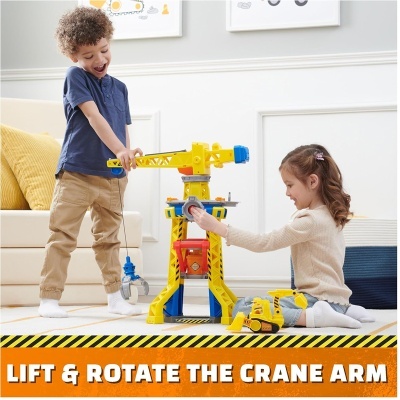 Crianças a brincar com brinquedo de guindaste amarelo e azul com texto LIFT & ROTATE THE CRANE ARM