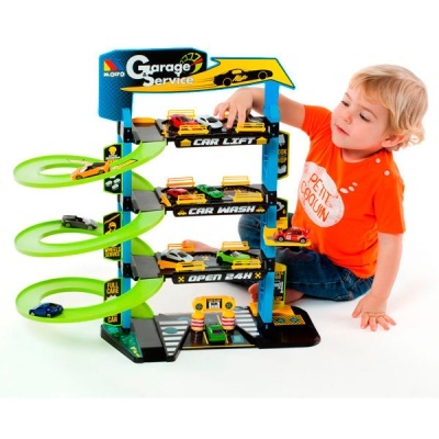 Estrutura de garagem de brinquedo em plástico com rampas verdes e carros pequenos.