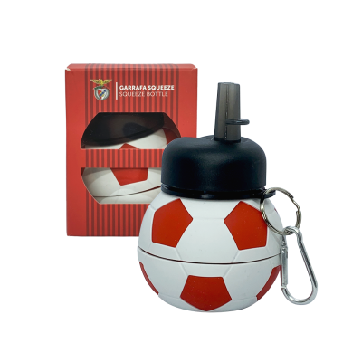 Garrafa squeeze em forma de bola de futebol com tampa preta e mosquetão ao lado da embalagem vermelha.