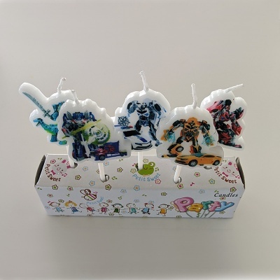 Velas de aniversário com desenhos de robôs e carros sobre caixa decorativa infantil