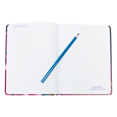 Caderno aberto com páginas pautadas e lápis azul no meio