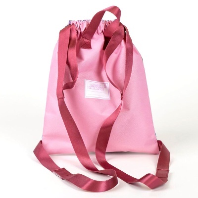 Mochila tipo saco rosa claro com alças vermelhas escuras e etiqueta branca