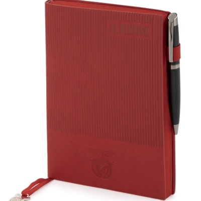 Caderno vermelho SL Benfica com textura riscada, emblema e caneta preta na lateral.