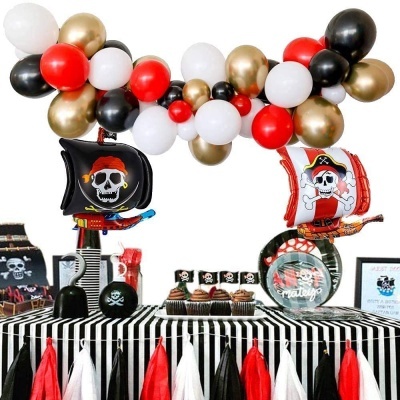 Decoração de festa pirata com balões e mesa às riscas com cupcakes