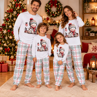 Família com pijamas natalícios combinando em ambiente decorado para o Natal