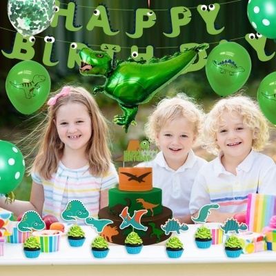 Decoração festiva de aniversário com tema de dinossauros, inclusivamente balões e bolo coloridos.