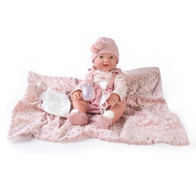 Boneca bebé vestida com roupa cor-de-rosa sentada numa manta cor-de-rosa