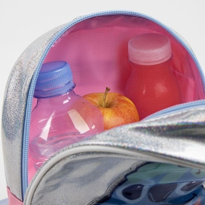 Mochila prateada aberta com garrafa de água, maçã e garrafa vermelha no interior