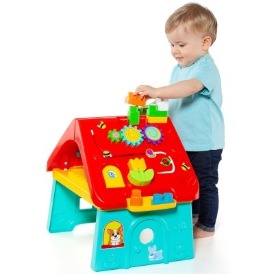 criança a brincar com casa de brinquedo colorida em plástico