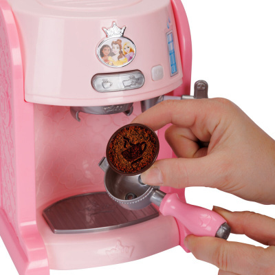 Máquina de café de brinquedo rosa com desenhos de princesas e tampa com símbolo de chávena.