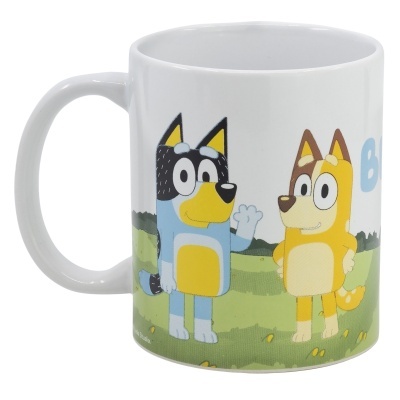 Caneca branca com desenhos animados de cães coloridos e relva de fundo