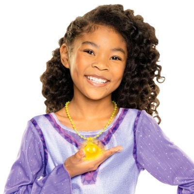 Menina com vestido roxo e colar amarelo segurando bola amarela