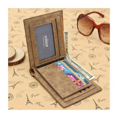 Carteira castanha masculina aberta com cartões e notas, sobre papel decorado com Torre Eiffel e texto Paris, com óculos castanhos ao lado