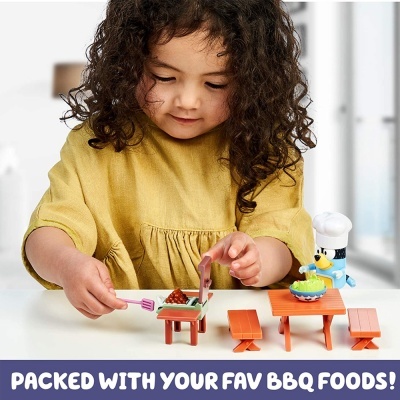 Criança a brincar com conjunto de brinquedos de churrasqueira coloridos