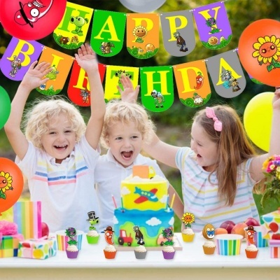 Crianças numa festa de aniversário com bolo azul e amarelo, cupcakes e faixa HAPPY BIRTHDAY colorida